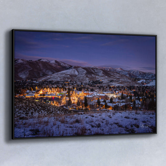 Snowy mountain town glowing with warm lights at twilight in winter.