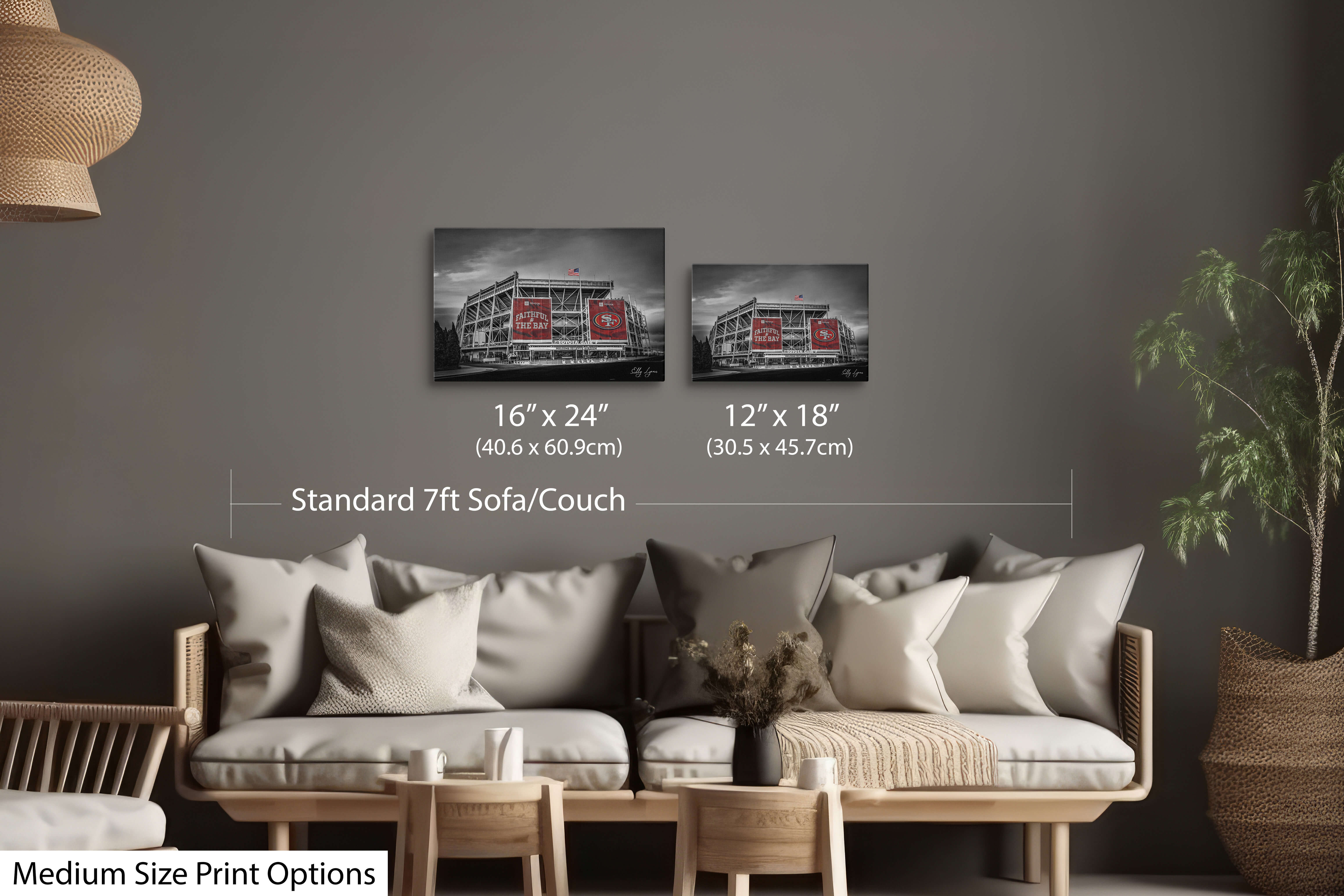 Neutral-toned room featuring two medium black and white Levi’s Stadium prints with red banners, shown above a standard sofa.